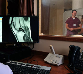 technician explaining the open sided mri to a patient